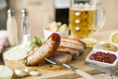 Çatal, ketçap, hardal, bira ile domuz sosisi ızgara sosis,