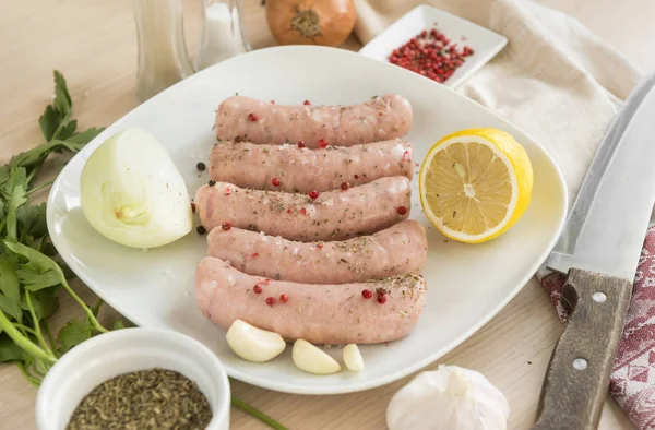 raw sausages, pork sausages on a plate, spices, knife