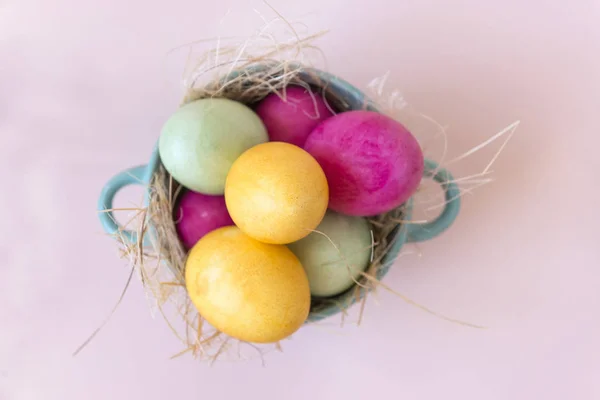 Rosa, amarillo, verde Huevos de Pascua en un plato, vista superior — Foto de Stock