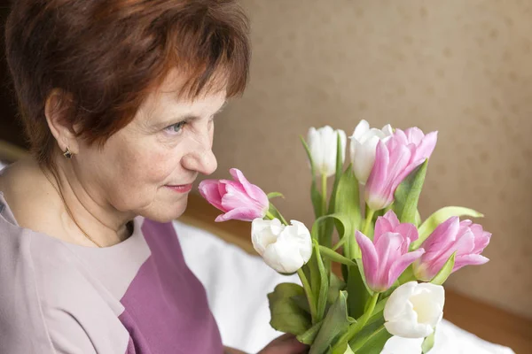 Белая взрослая женщина с букетом белых и розовых тюльпанов — стоковое фото