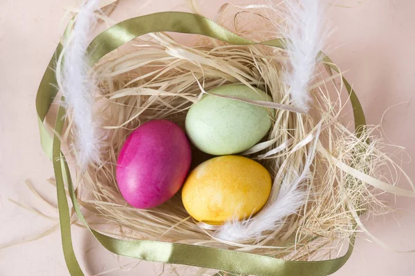 3 huevos, Pascua, rosa, amarillo, huevos verdes en el nido, hazaña blanca — Foto de Stock