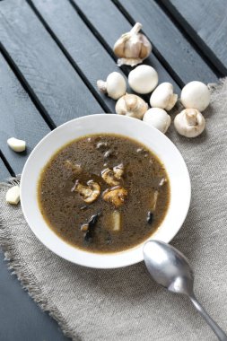 Beyaz plaka mantar çorbası, ahşap sörf taze mantar