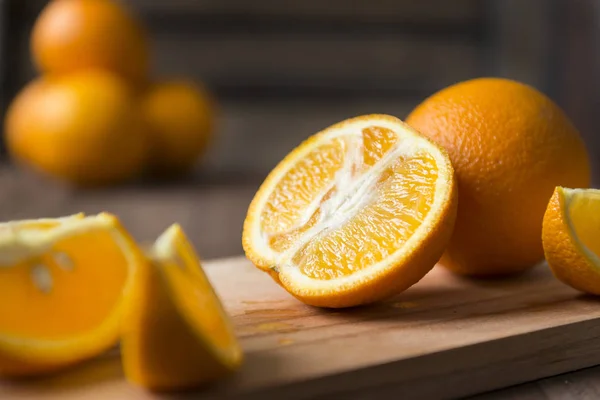 Orangenstückchen auf Holzgrund, Zitrusfrüchte, viele Orang-Utans — Stockfoto