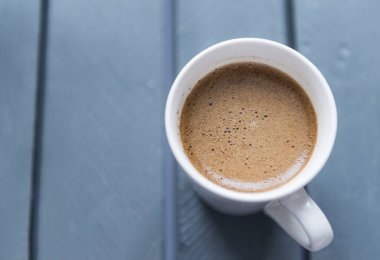 gri arka planda siyah kahve ile beyaz kupa, üst görünüm