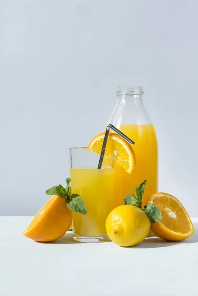 Vidro e garrafa de suco de laranja com hortelã, laranja meio fresco, l — Fotografia de Stock