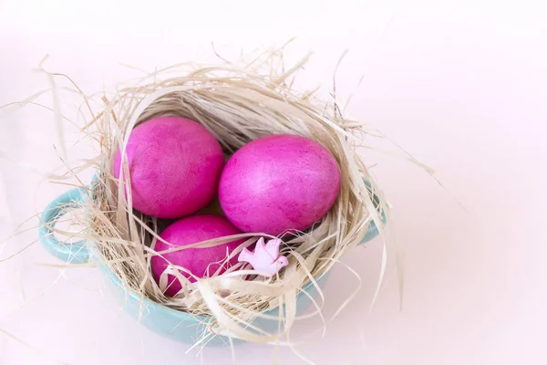 3 huevos rosados en un nido sobre un fondo beige, Pascua, palomas, plat — Foto de Stock