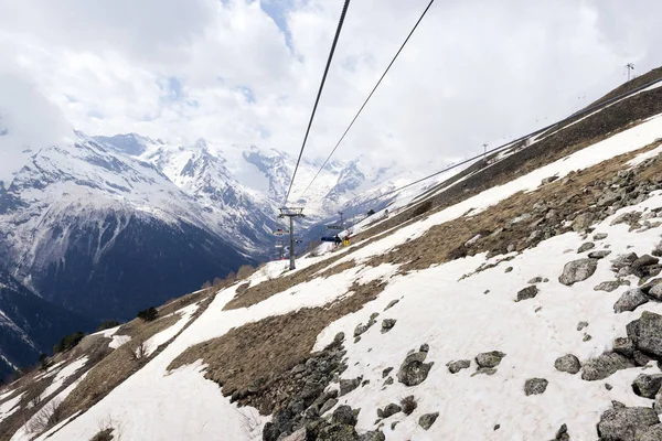 cable car on the mountainside in spring, snow on the slope of th