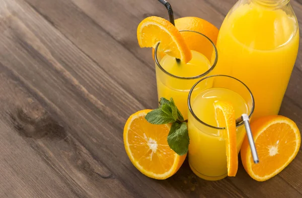 2 склянки апельсинового соку зі скибочками апельсина та гілочками м'яти — стокове фото