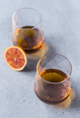 Gri bir arka plan üzerinde konyak 2 bardak, turuncu bir parça