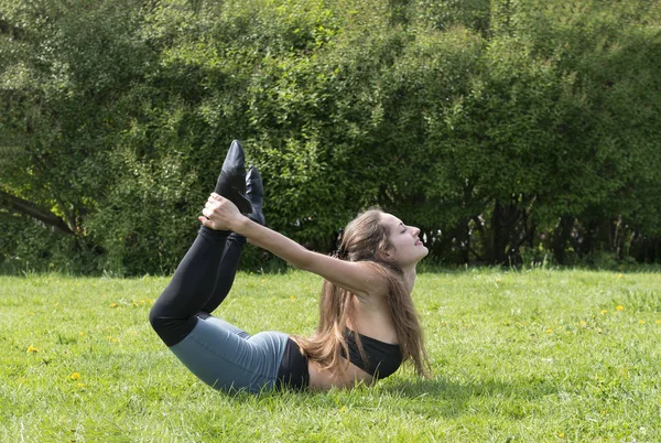 Mädchen umklammerte ihre Beine mit ihren Händen, Mädchen beim Yoga — Stockfoto