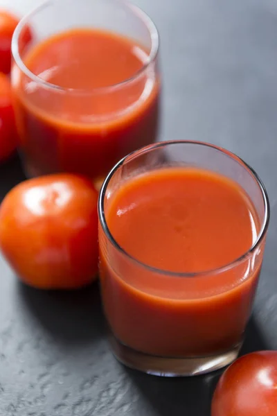 2 tazas de jugo de tomate, tomates frescos sobre fondo negro —  Fotos de Stock