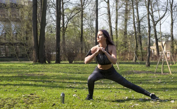Szczupła dziewczyna w odzieży sportowej jest zaangażowany w fitness w parku — Zdjęcie stockowe