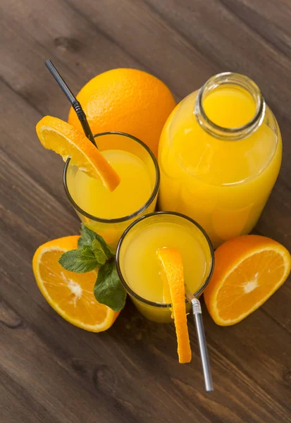 2 чашки і пляшка апельсинового соку зі скибочками свіжого апельсина — стокове фото