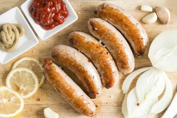 Salsichas fritas de carne com cebolas, ketchup e mostarda em uma madeira — Fotografia de Stock