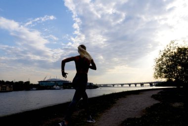 koşucu, 1 ince kız gün batımında nehir Bankası boyunca çalışan
