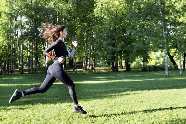 1 white girl with long hair in sports clothes running on the gra — Stock Photo, Image