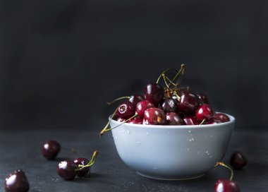 koyu arka plan, çilek olgun taze kiraz ile derin plaka