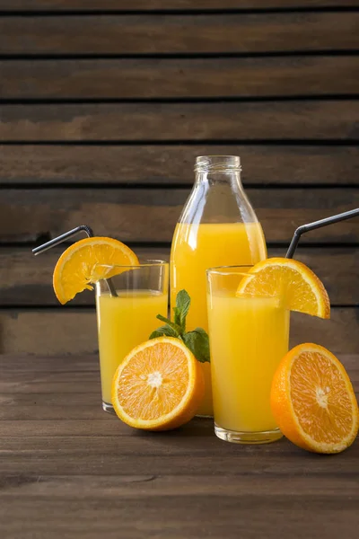 2 чашки апельсинового соку зі скибочками свіжого апельсина, пляшка соку на — стокове фото