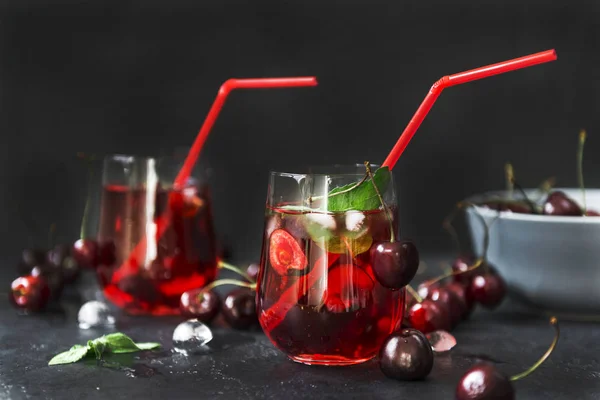 Cherry juice, lemonade with cherries in a glass on a black backg — Stock Photo, Image