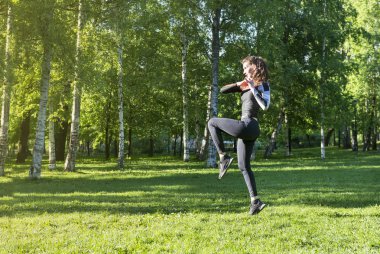 yeşil ağaçlar arasında Parkta spor yapan ince kız