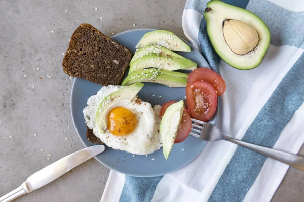 sandwich with fried egg, avocado, tomato, sesame, wholegrain bre