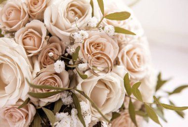 Bir buket gülün üzerinde 2 altın alyans, gelin buketi, akış.