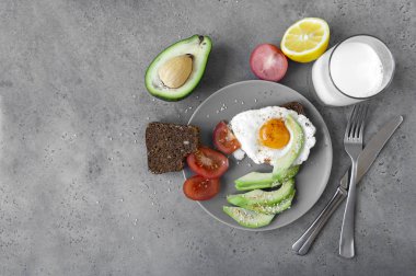 Kahvaltı tabağı, çırpılmış yumurta ekmek, avokado dilimleri, domates.