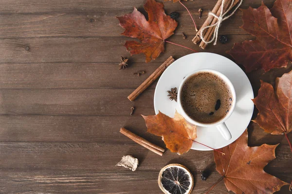 Bir fincan sade kahveyle bir fincan çay tabağı içinde, ahşap bir taşrada.