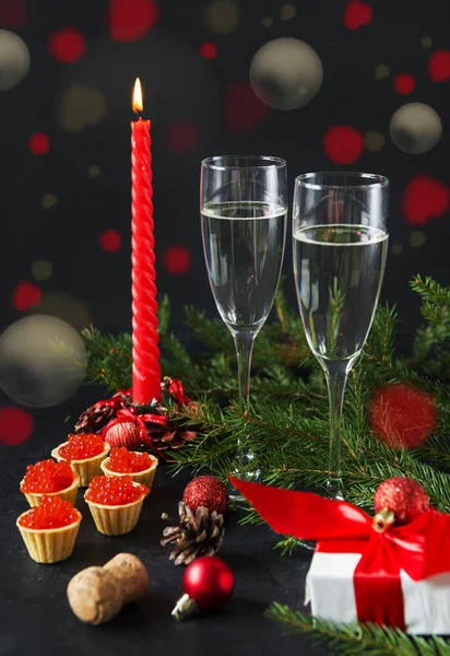 Pohár pezsgő, piros gyertya, tartályok vörös kaviárral, ajándék — Stock Fotó