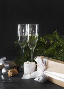 Karanlıkta köknar dallarının arka planında bir kadeh şampanya.