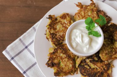 Bir tabak kabaklı börek, ekşi krema ve yeşillik.