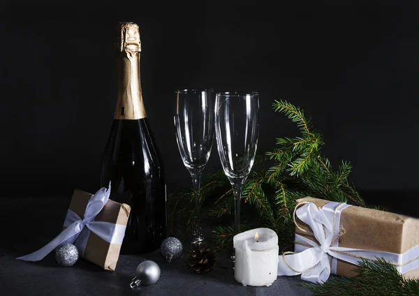 1 flaska champagne, 2 glas, gran grenar i mörkret på en — Stockfoto
