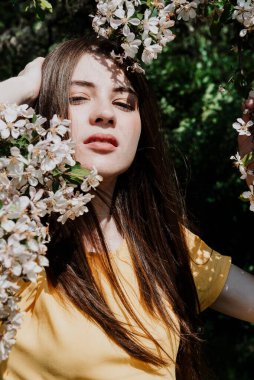 1 beyaz, uzun saçlı, sarı elbiseli, pembe elma çiçekleri arasında, çiçek açan bir kadın.