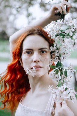 1 beyaz, güzel stil sahibi, kızıl saçlı, çilli, pembe elbiseli, kiraz çiçekli bir kadın.