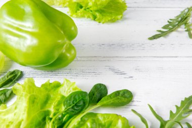 marul yaprakları, biber, roka, yeşil ıspanak, beyaz ahşap otlar 