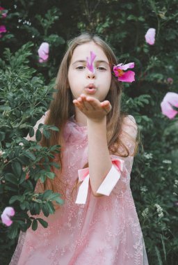 1 beyaz kız. 10 yaşında. Pembe elbiseli. Yeşil yapraklı.