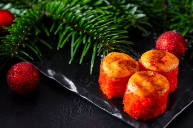 Japon suşisi, havyar ve yumuşak peynirli fırında ekmek, köknar dalları, kırmızı Noel topları.,