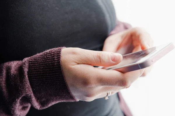 smartphone in the hands of a person on a light background