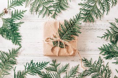 1 kutuda eşkıyanın yeşil dalları için bir hediye beyaz ahşap arka planda köknar dalları, kozalaklı dallar