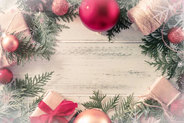 Köknar dalları, kırmızı ve altın Noel topları, hediyeli kutular, thuja, ipli makara, beyaz ahşap arka planda yazmak için bir yer.