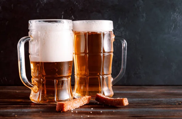 Mugs Light Beer Foam Snacks Croutons Dark Wooden Background — Stock Photo, Image