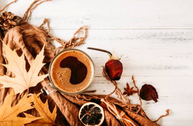 sıcak siyah kahve kupası, kahverengi eşarp, sarı akçaağaç sonbahar yaprakları, beyaz ahşap arka planda kurumuş gül, kopyalama alanı