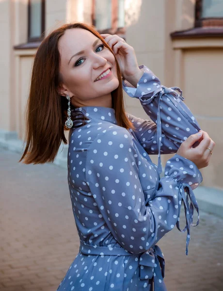 1ヨーロッパの赤い髪の女性でグレーPolkaドットドレス笑顔で通りの近くに — ストック写真