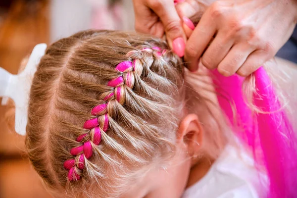 ブロンドの女の子はピンクの鎖 美容師と編組 — ストック写真