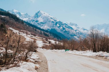 Kuzey Kafkasya 'daki dağ vadisine giden yol, karlı dağ zirveleri.,