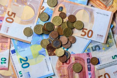 Ekonomi, tasarruf ve gelir sembolü olarak mali geçmiş olarak düzenlenmiş avro banknotları ve sikkeler.