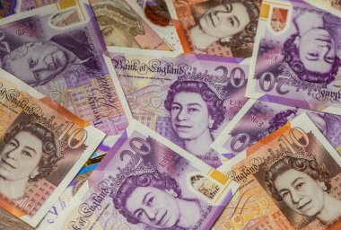 İngiltere para birimi ve monarşisinde geçiş sembolü Kral III. Charles ve Kraliçe II. Elizabeth 'in portrelerinin yer aldığı İngiliz 20 pound banknotlarının yakın çekimi.