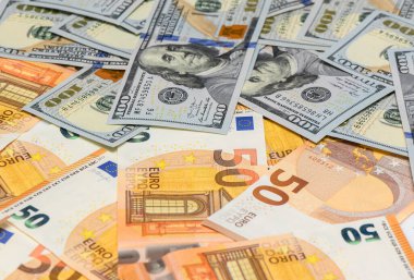 Yakın plan 100 ABD Doları banknotları 50 euro ile karıştırılmış, Forex ticaret, uluslararası ticaret ve küresel finans piyasaları sembolü.