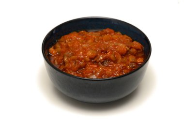 Beyaz arka planda siyah tabakta sebzeli haşlanmış patlıcan.