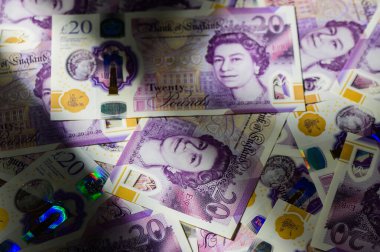 Birleşik Krallık 'tan gelen 20 banknotun makro yakın plan çekimleri dokuyu ve tasarımı, zenginliği, tasarrufu ve ekonomiyi sembolize eden finansal bir arka plan oluşturur..